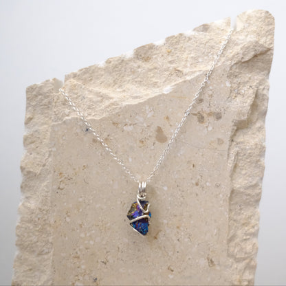 Close-up of iridescent Chalcopyrite pendant with silver wire wrapping
