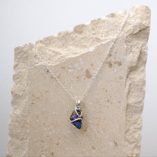Close-up of iridescent Chalcopyrite pendant with silver wire wrapping
