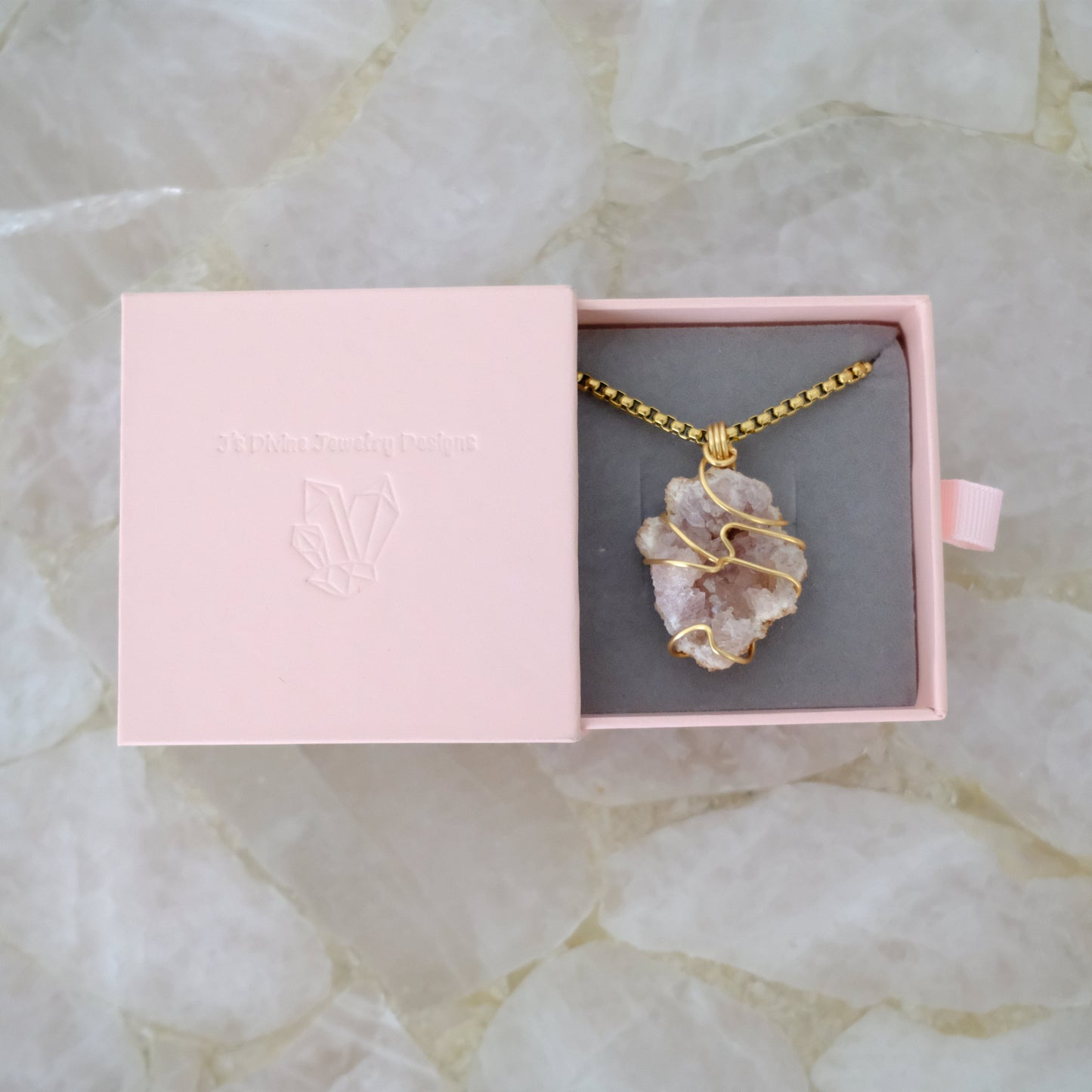 Pink Amethyst gold plated necklace with a crystal pendant in an open pink jewelry box