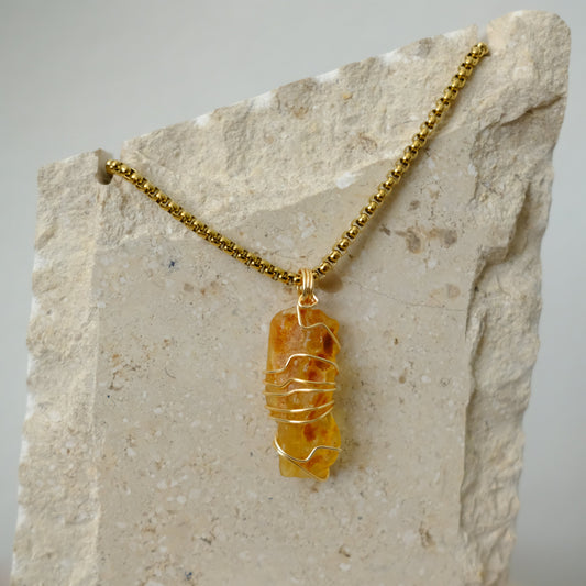 Close-up of gold-plated amber necklace showcasing rich amber crystal details and artisan craftsmanship.