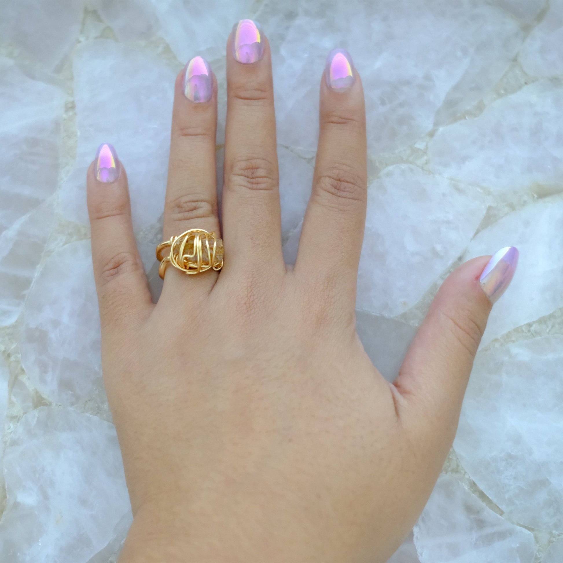 Hand wearing handmade gold plated golden topaz ring with adjustable band and natural gemstone.
