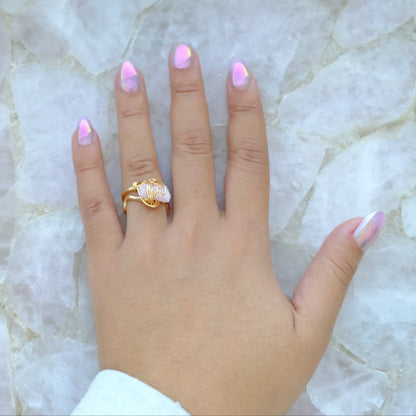 Close-up of a hand wearing a handmade gold plated pink tourmaline ring with natural gemstone and adjustable band.